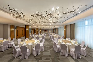 A banquet hall with round tables, white chairs, and a decorative ceiling. - Holiday Inn Ningde Jiaocheng (Ningde)