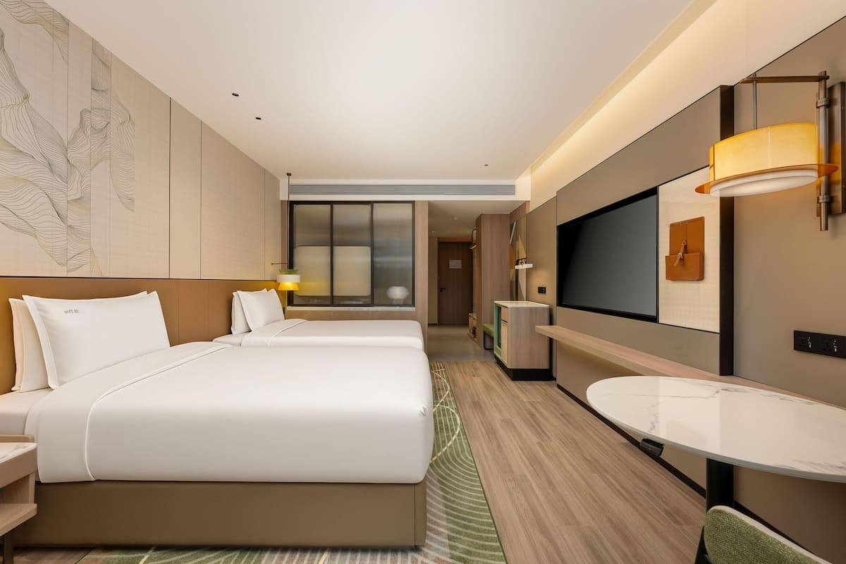 Ein Hotelzimmer mit einem großen Bett, einem Schreibtisch, einem Fernseher und einem Badezimmer.