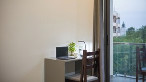 A balcony with a laptop, a potted plant, and a chair. - Alaya Stays By Elivaas Lake City Heights (Udaipur)