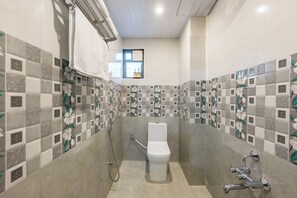 A bathroom with a toilet, shower, and a window. - Alaya Stays By Elivaas Lake City Heights (Udaipur)