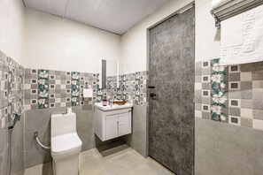 Une salle de bain avec des toilettes, un lavabo et une douche.