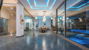Ein modernes Interieur mit Essbereich, einer großen Glaswand und einem Pool.