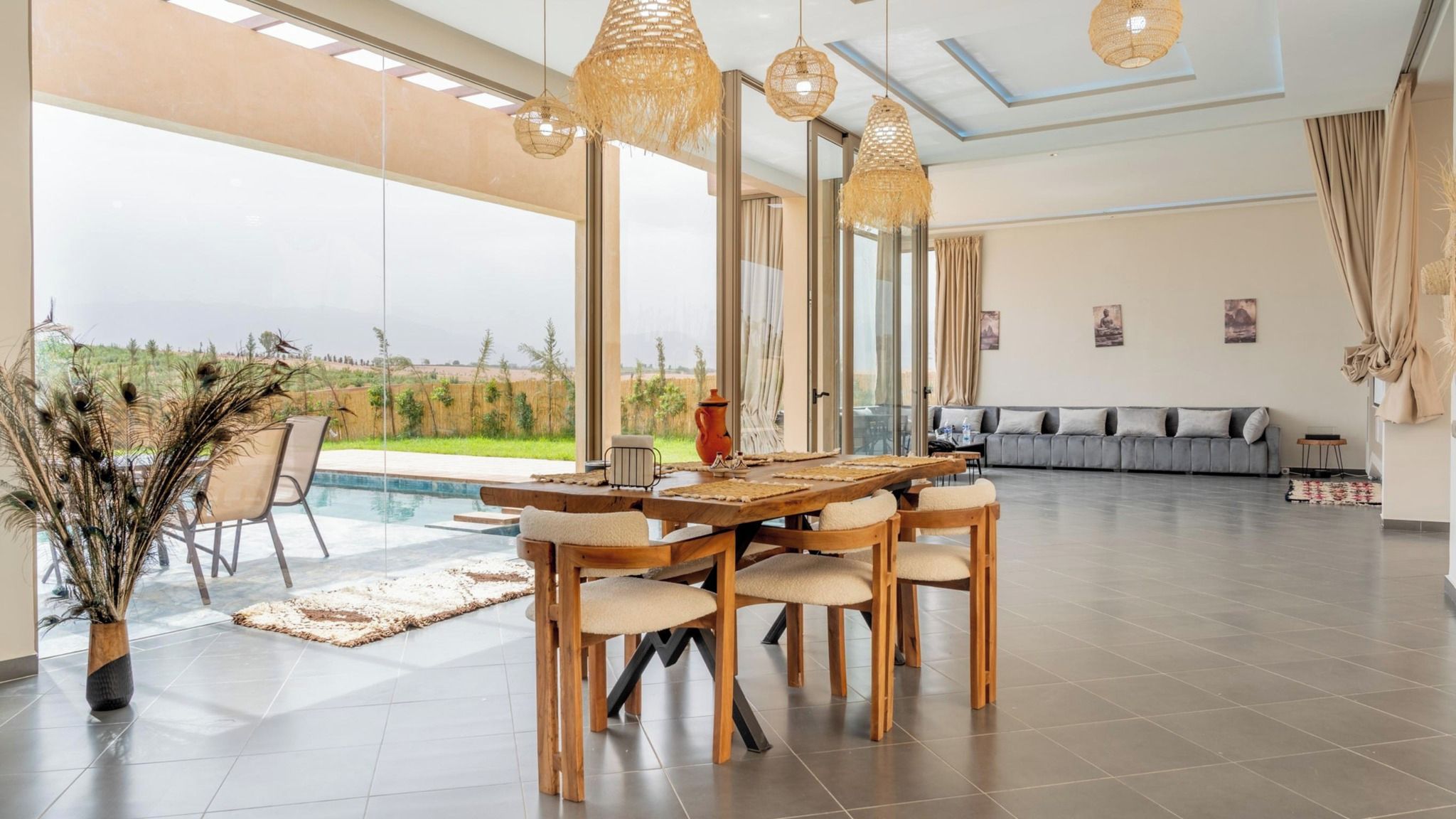 A spacious living area with a large dining table, comfortable seating, and a view of the outdoors.