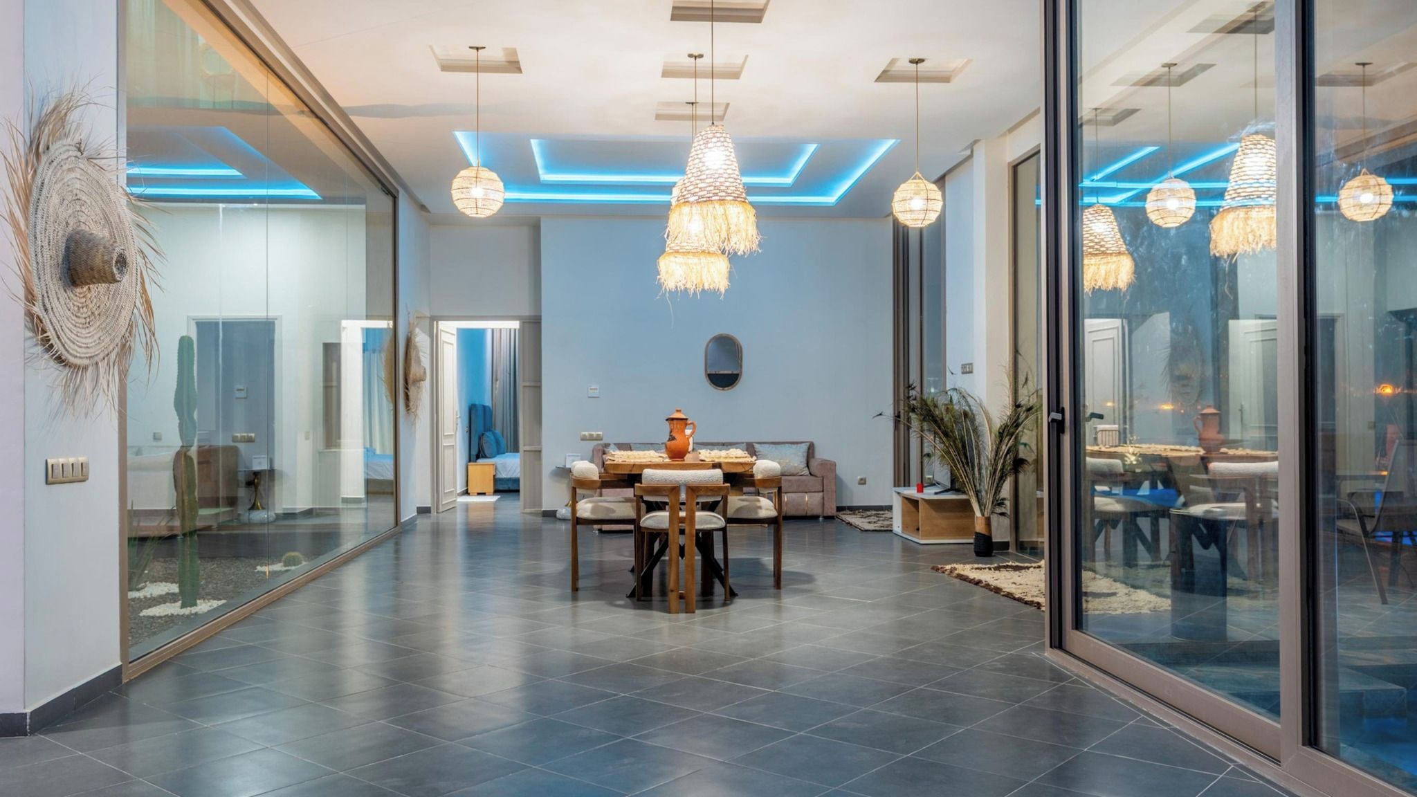 Ein modernes Interieur mit Essbereich, großen Fenstern und zeitgemäßen Leuchten.