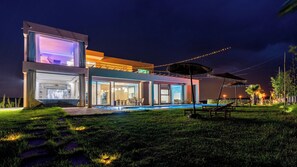 A modern two-story house with a swimming pool, outdoor seating, and string lights. - Life Resort (Marrakech)