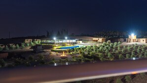 Ein modernes Gebäude mit Pool, umgeben von angelegten Gärten und Bäumen.