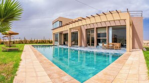 A modern house with a swimming pool, large windows, and outdoor seating. - Life Resort (Marrakech)