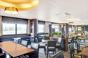 A modern restaurant with booths and tables, large windows, and a view of the outside. - Belvilla Aberdeen Bridge of Don Sea View (Aberdeen)