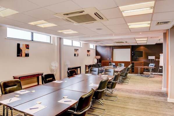 A conference room with a long table, chairs, a projector screen, and a whiteboard. - Belvilla Aberdeen Bridge of Don Sea View (Aberdeen)