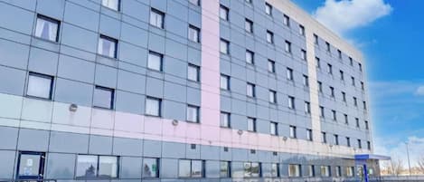 A multi-story hotel with a modern facade, large windows, and a visible entrance.