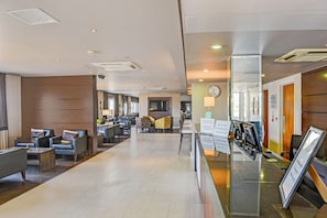 A hotel lobby with a reception desk, seating area, and a TV screen. - Belvilla Aberdeen Bridge of Don Sea View (Aberdeen)