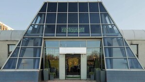 Un restaurant moderne doté d’une façade en verre et d’une entrée triangulaire.