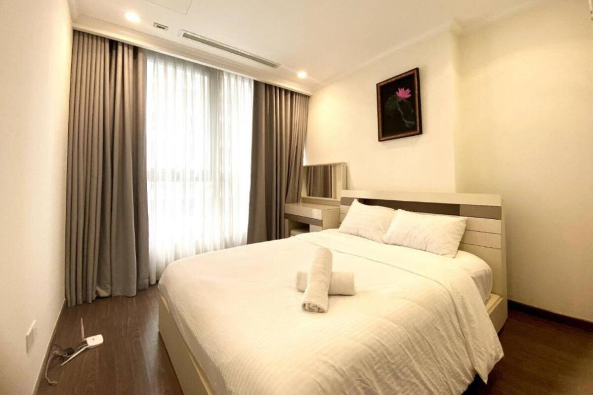 Habitación de hotel con una cama grande, una mesita de noche, una lámpara y un cuadro en la pared.