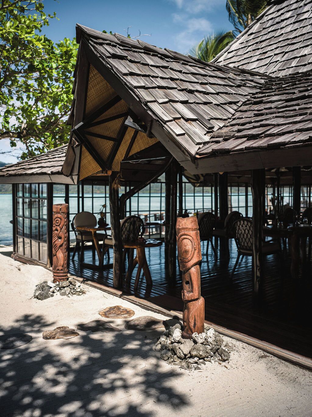 A wooden structure with a thatched roof overlooking a body of water.