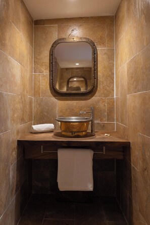 A bathroom with a wooden vanity, a round sink, a mirror, and a towel rack. - Vahine Private Island (Taha'a)