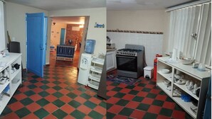 Une cuisine avec un carrelage à motifs, une cuisinière, un distributeur d’eau et des étagères remplies de vaisselle.