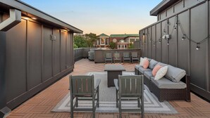 Un espacio al aire libre con patio, un sofá, sillas y una mesa.