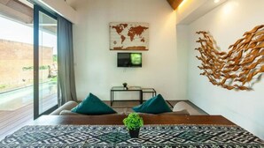 Un salon moderne doté d’une grande fenêtre, d’une œuvre d’art représentant une carte du monde, d’un téléviseur à écran plat et d’une sculpture murale originale.