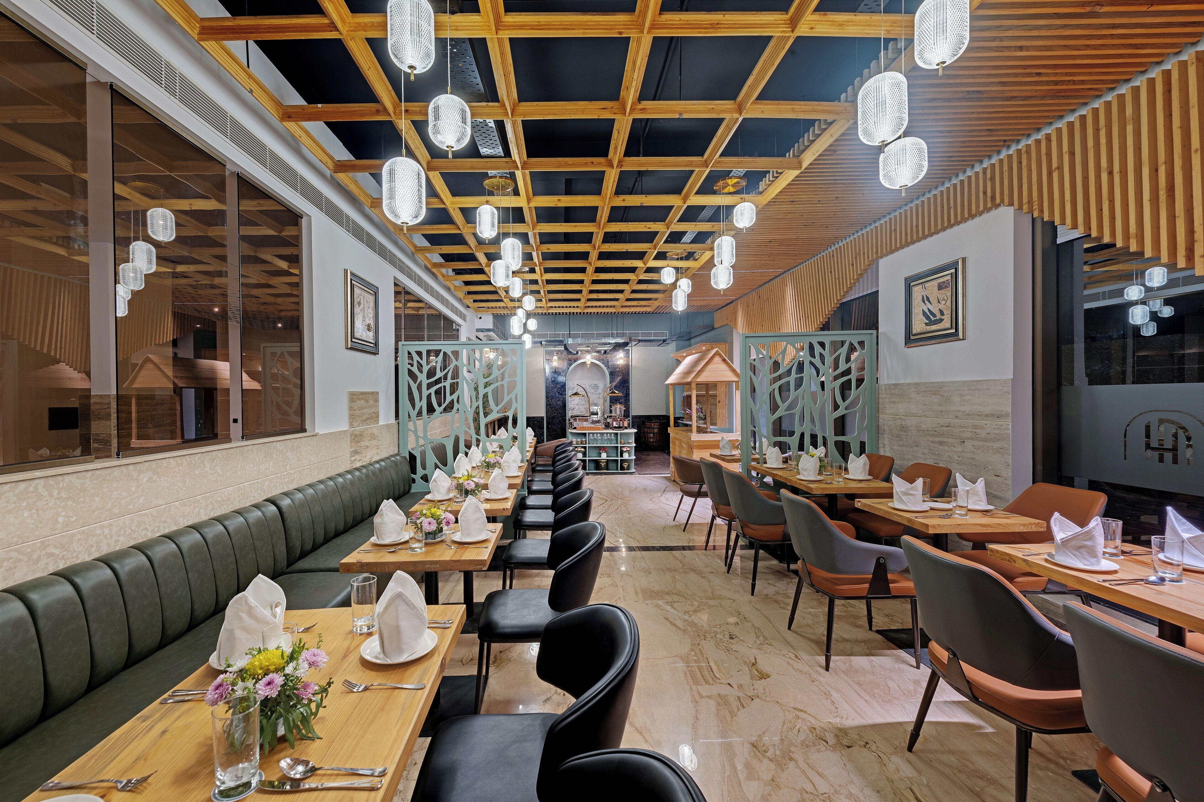 Un restaurant doté d’un long comptoir, de banquettes et d’un plafond haut orné de luminaires suspendus.
