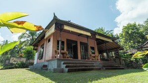 A traditional brick building with a tiled roof, a front porch, and steps leading up to the entrance. - Pondok Hari Baik (Selemadeg)