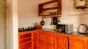 A kitchen with wooden cabinets, a microwave, a toaster, and a kettle. - Your nest and serenity (Arusha)