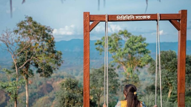 A wooden swing set with a view of a mountainous landscape. - Niribili Eco Resort (Sajek)
