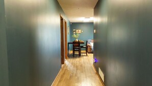 A narrow hallway with wooden flooring and teal walls. - Peaceful Guest House Beside The Elks Golf Course – A Relaxing Country Getaway (Kearney)