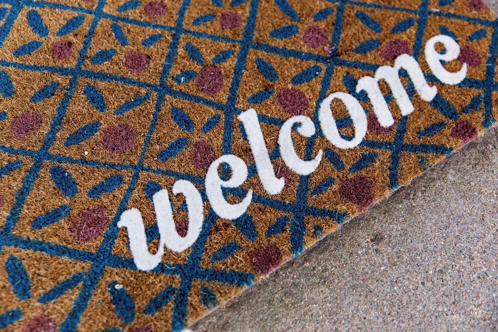 A welcome mat with a geometric pattern and the word "Welcome" in white letters.