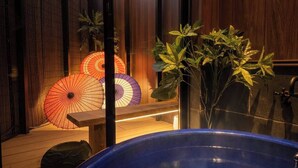 A room with a wooden bench, a blue bathtub, and decorative umbrellas. - Kanazawaya Motogikucho (Kanazawa)