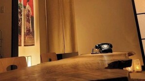 A traditional Japanese room with tatami flooring, a shoji screen, a hanging paper lantern, and a vintage telephone. - Kanazawaya Motogikucho (Kanazawa)