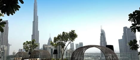 A rooftop lounge with modern seating and a view of the Burj Khalifa.