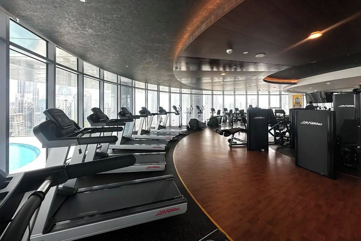 Une salle de sport équipée de tapis de course, de poids et d’appareils de musculation cardiovasculaire.
