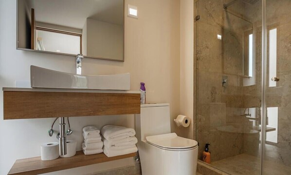 A bathroom with a sink, mirror, toilet, and shower. - Oceanview Condo CaboCosta Balandra (Cabo San Lucas)