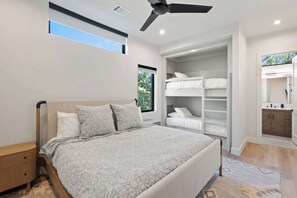 Een slaapkamer met een bed, een inbouwkast en een plafondventilator.