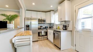 Een koffiezetapparaat/waterkoker, kookgerei, borden en bestek