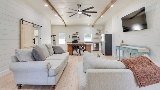 A spacious living area with a sofa, a coffee table, and a TV mounted on the wall.