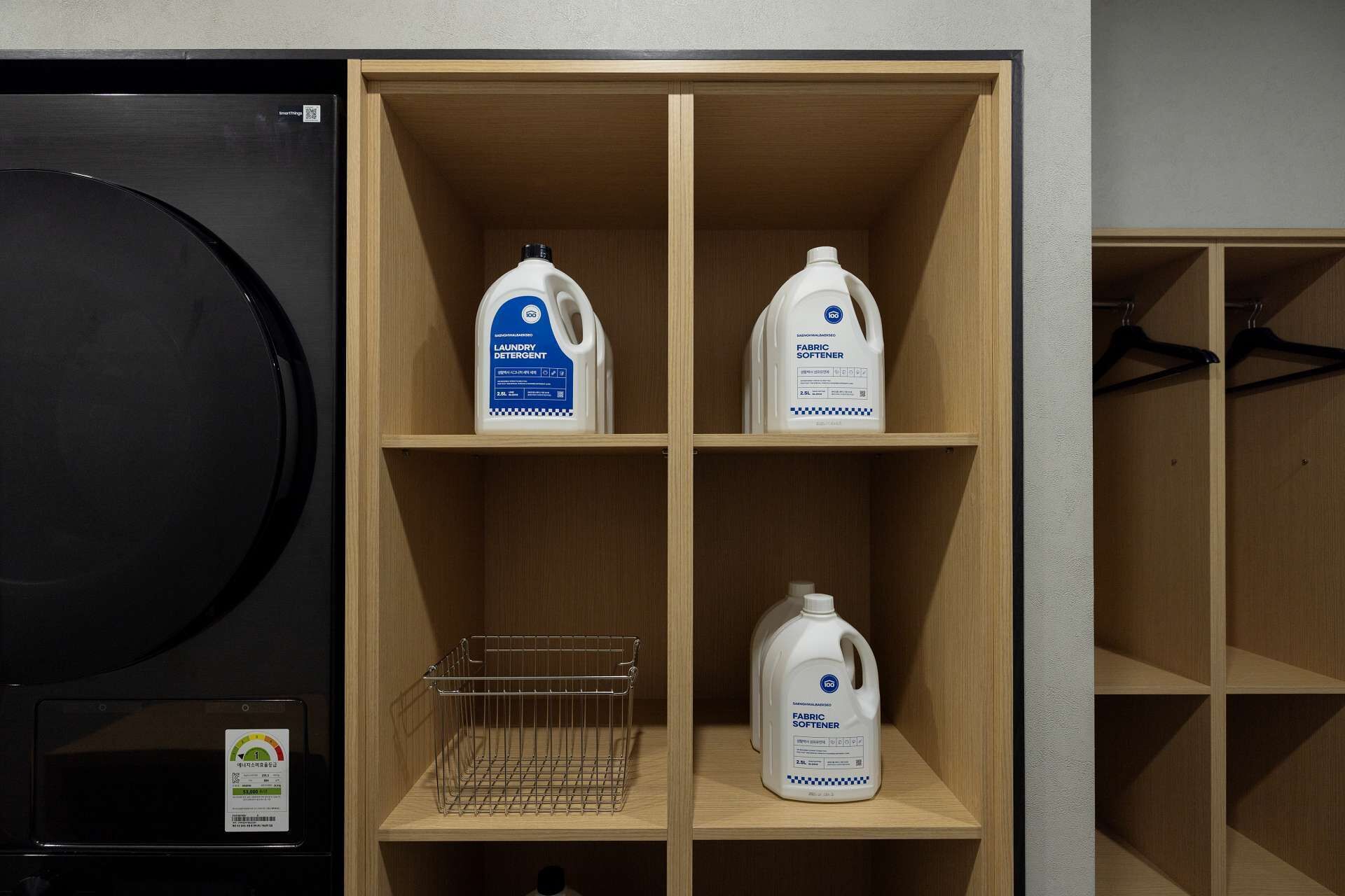 A laundry room with shelves holding detergent and fabric softener bottles.