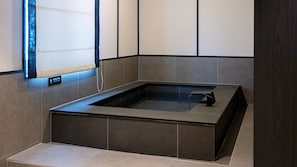 A modern spa room with a rectangular hot tub, tiled walls, and a bench. - Mitasuya Ryokan Hotel by Anook Daejeon Yuseong (Daejeon)