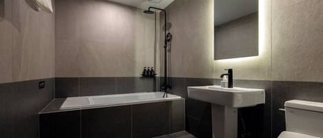 Et moderne badeværelse med badekar, håndvask og toilet.