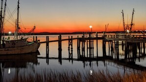 Un molo con barche e un tramonto sullo sfondo.