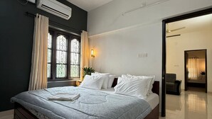 A modern bedroom with a large bed, a ceiling fan, and a window with curtains.
