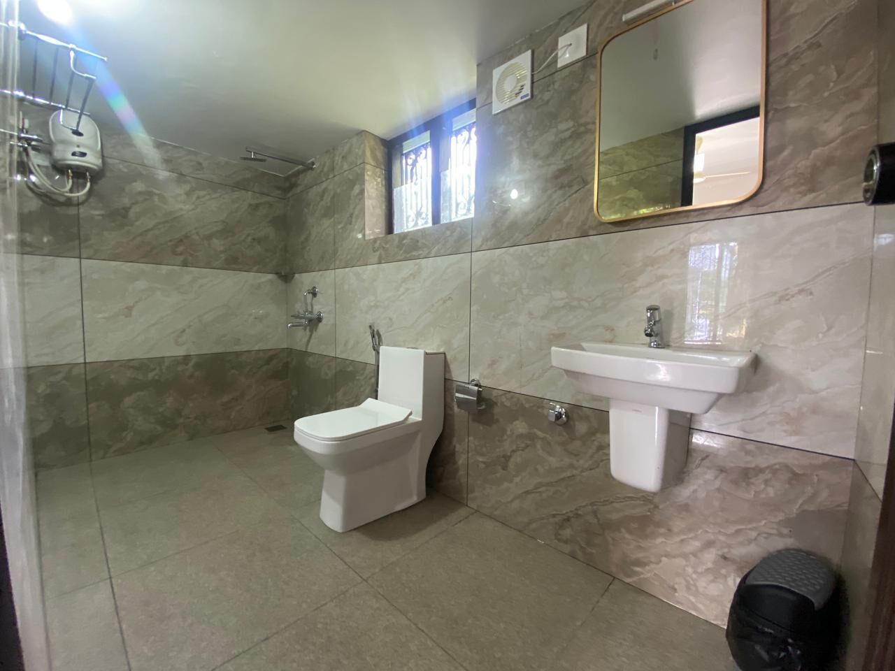A bathroom with a toilet, sink, and shower.