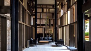 Ein modernes Interieur mit einer zentralen Sitzecke, hohen Decken und großen Fenstern.