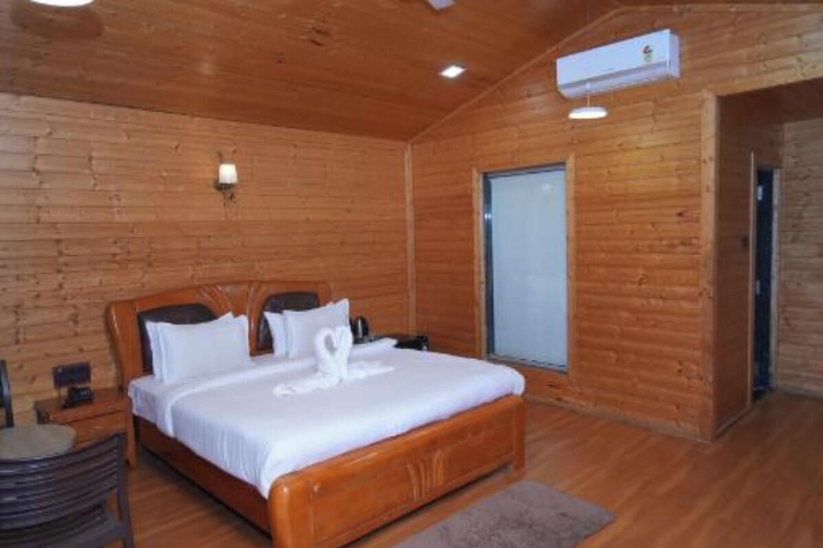 Une chambre à coucher aux murs lambrissés, avec un lit, une table de chevet et un climatiseur fixé au mur.