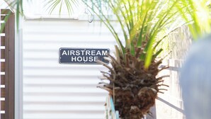 A sign reading "AIRSTREAM HOUSE" with a palm tree in the foreground.