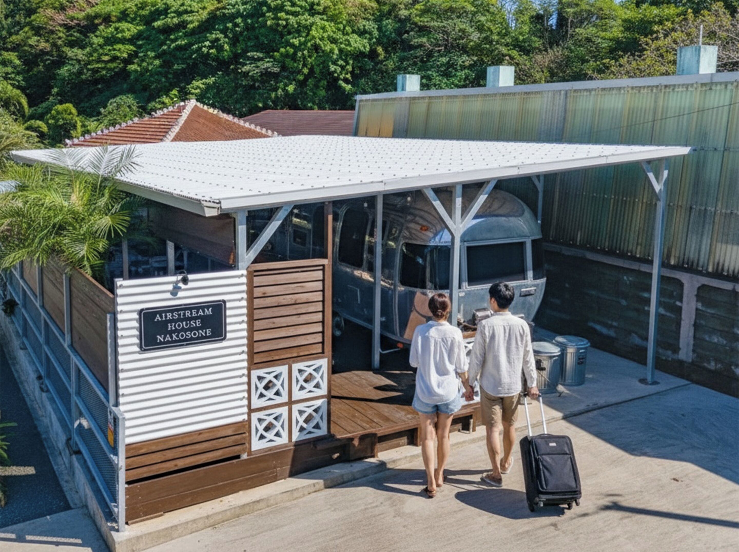 A small, single-story structure with a white roof and wooden walls, labeled "AIRSTREAM HOUSE NAKOSONB."