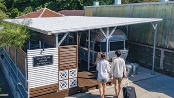 A small, single-story structure with a white roof and wooden walls, labeled "AIRSTREAM HOUSE NAKOSONB."
