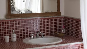 A bathroom with a sink, mirror, and red-tiled walls. - Historic home, wonderful view of the hills, 20" from the Royal Palace of Caserta. (Caiazzo)