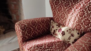 A corner sofa with a floral pattern, a matching cushion, and a hexagonal patterned floor. - Historic home, wonderful view of the hills, 20" from the Royal Palace of Caserta. (Caiazzo)