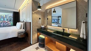 Ein modernes Badezimmer mit einem großen Spiegel, zwei Waschbecken und einem Waschtisch mit Stauraum.